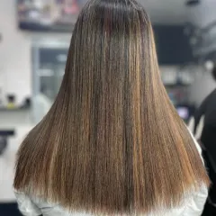 This is the result of a professional straightening treatment. The hair is perfectly uniform from root to tip, with a healthy shine that indicates it was done with care to protect the hair's integrity.