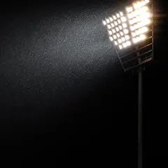 Even rain can't stop the game. A stadium floodlight cuts through the downpour, an atmospheric shot that captures the challenging conditions of a match.