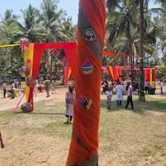We add small, thematic details throughout the venue. A palm tree wrapped in orange fabric and adorned with Holi-themed cutouts adds to the festive ambiance of this outdoor corporate celebration.