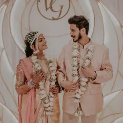 A happy couple during their Sakharpuda (engagement), wearing our elegant white rose varmalas.