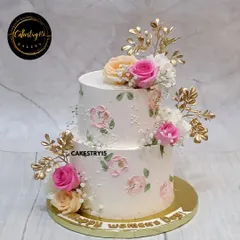 A graceful two-tier cake celebrating Women's Day. This 3kg blueberry creation is adorned with fresh pink and peach roses, golden leaves, and delicate hand-painted floral details.