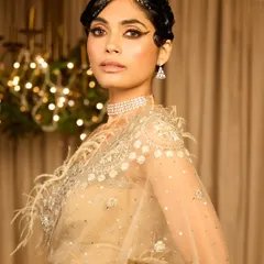 A direct look at this stunning Gatsby-themed style. The combination of the sculpted hair, bold eye makeup, and feathered saree creates a complete and unforgettable vintage look.
