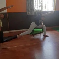 This is what a typical adaptive class looks like. We are using chairs to find stability and alignment in Virabhadrasana, or Warrior Pose. This modification makes the pose accessible for those with knee issues or balance concerns, allowing everyone to build strength safely.