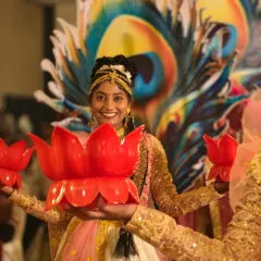 A close-up of our performer during a welcome dance. The combination of the peacock feather backdrop and lotus diyas showcases our ability to blend different traditional motifs.