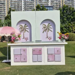 The custom-built bar for our pastel-themed event. The front panels were designed with a checkerboard and palm tree motif, while the arched back featured elegant palm illustrations, tying perfectly into the "prints, palms, and petals" concept.