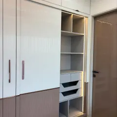 A combination wardrobe unit featuring both hinged and sliding doors for versatile access. The interior section is illuminated with built-in LED lights, highlighting the organized shelving and drawer system.