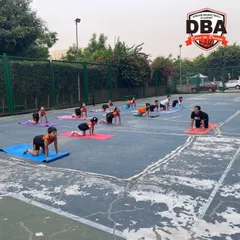 Here, the team practices the cat-cow pose on their mats. This exercise is excellent for improving spine flexibility and core stability, helping to prevent back injuries during intense physical activity.