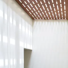 Light is a material we sculpt with. For this ceiling, we created a perforated wooden screen that filters light, casting dynamic patterns that shift throughout the day. It’s a detail that transforms the simple act of walking through a corridor into a subtle, poetic experience.