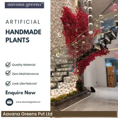 A magnificent handmade red flowering tree installed next to a modern staircase. This is a perfect example of how our custom trees can be designed to fit a specific space and create a powerful visual statement.