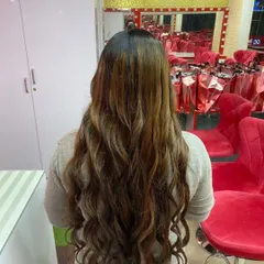 This is the art of color. A stunning balayage with warm, caramel tones blended seamlessly and styled into long, flowing curls. This look is perfect for adding dimension and richness.