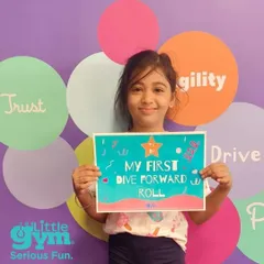 We love celebrating our students' progress. This young gymnast is proudly showing off her certificate for mastering her first dive forward roll. Her hard work and determination paid off.