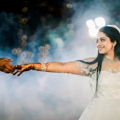 A dreamy, cinematic moment as the bride reaches for her groom's hand. The soft focus, the ethereal smoke, and her elegant white gown come together to create a scene straight out of a movie, showcasing my approach to capturing romantic, story-driven wedding photography.