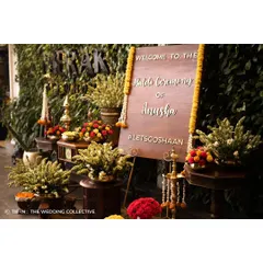 A custom wooden welcome sign, decorated with marigold garlands, greets guests at the entrance to the Haldi ceremony. This sets the tone for a traditional and festive event, rich with cultural details.