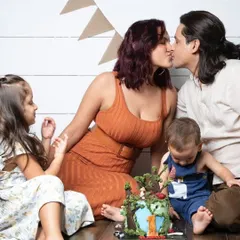 A first birthday cake smash is a family affair! This photo captures the sweet, messy, and loving moments of the celebration.