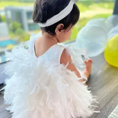 A view of the back of the white feather dress, showing its full, angelic silhouette. We ensure every angle is perfect for photos and for making your little one feel like she's in a fairytale.