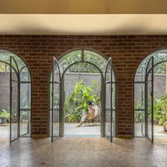 A series of grand arched doorways at the Ferns Cottage blurs the line between the living room and the garden. This design element allows natural light to flood the interiors and provides tranquil views of the courtyard from within.