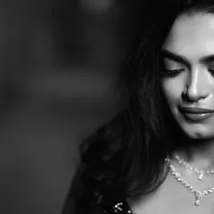 A timeless black and white portrait of the bride, her eyes closed in a moment of quiet contemplation. The shot beautifully highlights her delicate diamond necklace and elegant makeup.