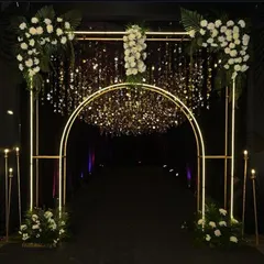 A modern and sleek entrance for a contemporary corporate event. The illuminated golden archway, accented with white florals and a sparkling curtain, provides a chic and sophisticated entry point for a product launch or cocktail party.