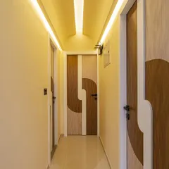 Even a simple passage can be a design feature. I used custom-designed doors with a unique two-tone laminate pattern and profile lighting in the ceiling to make this hallway feel elegant and intentional.
