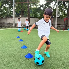 A young player from our U6 group navigates a cone drill, a fundamental exercise we use to develop dribbling and ball control from the very beginning.