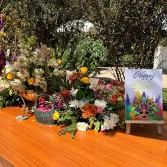 The welcome table for the Holi party, featuring a colorful art print and a beautiful arrangement of seasonal flowers.