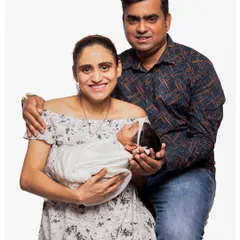 A classic family photograph with both parents and their newborn. This posed studio portrait is a perfect way to formally announce and celebrate your new family of three.