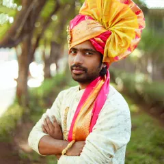 A strong portrait of a man wearing a traditional Pheta (turban) and kurta, captured outdoors. The focus is on his proud expression and the vibrant colors of his attire.