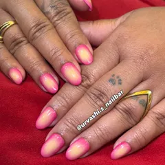 A beautiful and soft ombré manicure. The colors seamlessly blend from a sunny yellow at the base to a vibrant pink at the tips, creating a warm, sunset-inspired gradient with a glossy finish.