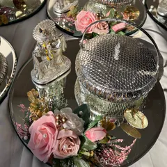 An elegant silver-themed platter perfect for a spiritual occasion. It features a silver lion idol, a decorative lidded bowl, and is accented with pink roses.