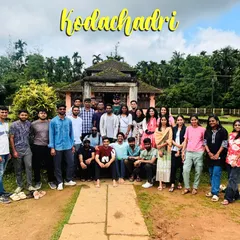 The group posing in front of a traditional house that serves as a homestay during the Kodachadri trek.