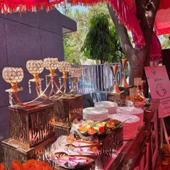 A close-up of our starter and salad station. The setup features ornate crystal candelabras, rustic wooden stands, and a variety of fresh salads and snacks, showcasing our attention to decorative detail.