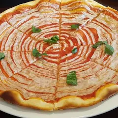 A visually striking pizza with a spiral of tomato sauce and my homemade vegan cheese, garnished with fresh basil.