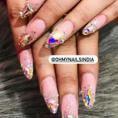 Showcasing our skill in stone art. These nails are heavily embellished with large, iridescent crystals and smaller surrounding stones for a dazzling, jewel-like effect.