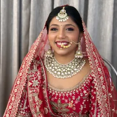 A radiant smile on a classic North Indian bride. I created this look with soft, glowing skin and a bold red lip to perfectly complement her stunning red lehenga for the main wedding ceremony.