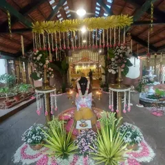 The central setup for the ceremony, featuring a beautiful floral rangoli made of fresh petals, traditional lamps, and arrangements of auspicious plants and flowers.