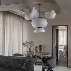 A cluster of sculptural pendant lights hangs over the dining area, acting as a functional art piece that defines the space.