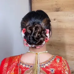 A beautifully woven floral bun using a mix of fresh flowers. This style adds a touch of natural elegance and is perfect for a daytime wedding or traditional ceremony.