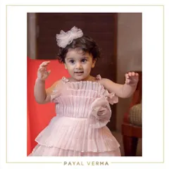 This little muse looks absolutely dreamy in her blush pink organza dress for her second birthday. The dress features delicate pleating on the bodice and a tiered skirt for extra twirl factor.