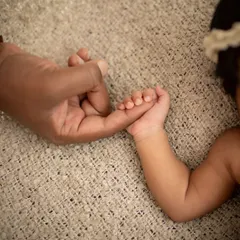 A tiny hand holding tight to mama's finger. This simple photo speaks volumes about the bond between a parent and child.