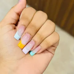 A fun and summery take on the French manicure, with each nail featuring a different pastel-colored tip on a square-shaped extension.