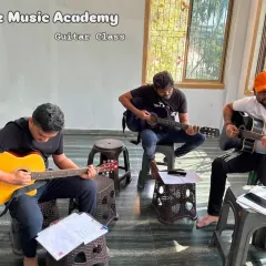 "Yes You Can." A snapshot of our adult guitar class, where students are learning together and motivating each other to master the instrument.