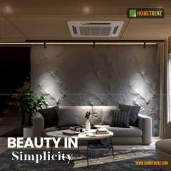 I find beauty in simplicity. This living room uses a textured concrete-finish wall, a simple grey sofa, and focused track lighting to create a minimalist yet warm and inviting atmosphere.