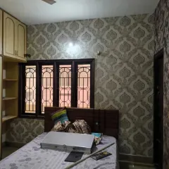 A full view of the bedroom, showing the grey damask wallpaper.