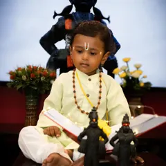 In this shot from the Varkari series, the little boy is posed with a book and prayer beads, adding a storytelling element to the festive baby photoshoot.