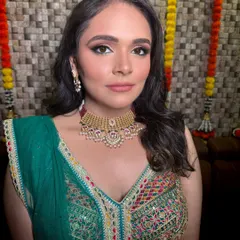 A stunning bride ready for her sangeet or mehendi. Her multi-colored lehenga is paired with a classic gold-tone choker, showing how simple jewellery can perfectly complement a vibrant outfit.