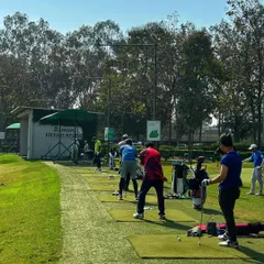 A Saturday well spent. The driving range is full of golfers enjoying the clear weather, with bags lined up and swings in full flow.
