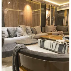 Here, we balanced dramatic elements with subtle textures. The oversized coffee table, crafted from a single block of Panda White marble, anchors the room, while the fluted and wood grain wall panels add warmth and depth.