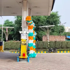 A spiral balloon garland wrapped around a pillar at a petrol station. This is a simple yet effective way to add a festive touch to commercial forecourts.
