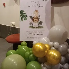 A personalized welcome sign is a great way to guide guests. This one for the 'Wild One' party matches the jungle theme and directs guests to the celebration area.