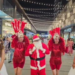 Our Santa Claus accompanied by two vibrant carnival dancers in red feathered costumes. These themed performers are perfect for parades, stage shows, and photo opportunities at any festive event.